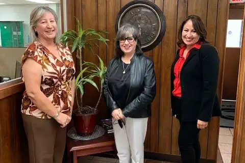 Trois collègues chez Clowe & Cowan of El Paso posant dans le vestibule du bureau